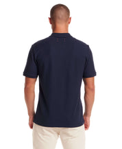 Back view of a man wearing a Short Sleeve Honeycomb Pique Polo Shirt in Peacoat, featuring a classic silhouette.