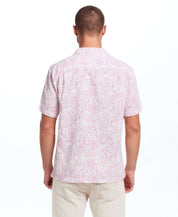 Back view of a man wearing a short sleeve linen cotton camp shirt in Wild Rose with a bold leaf print.