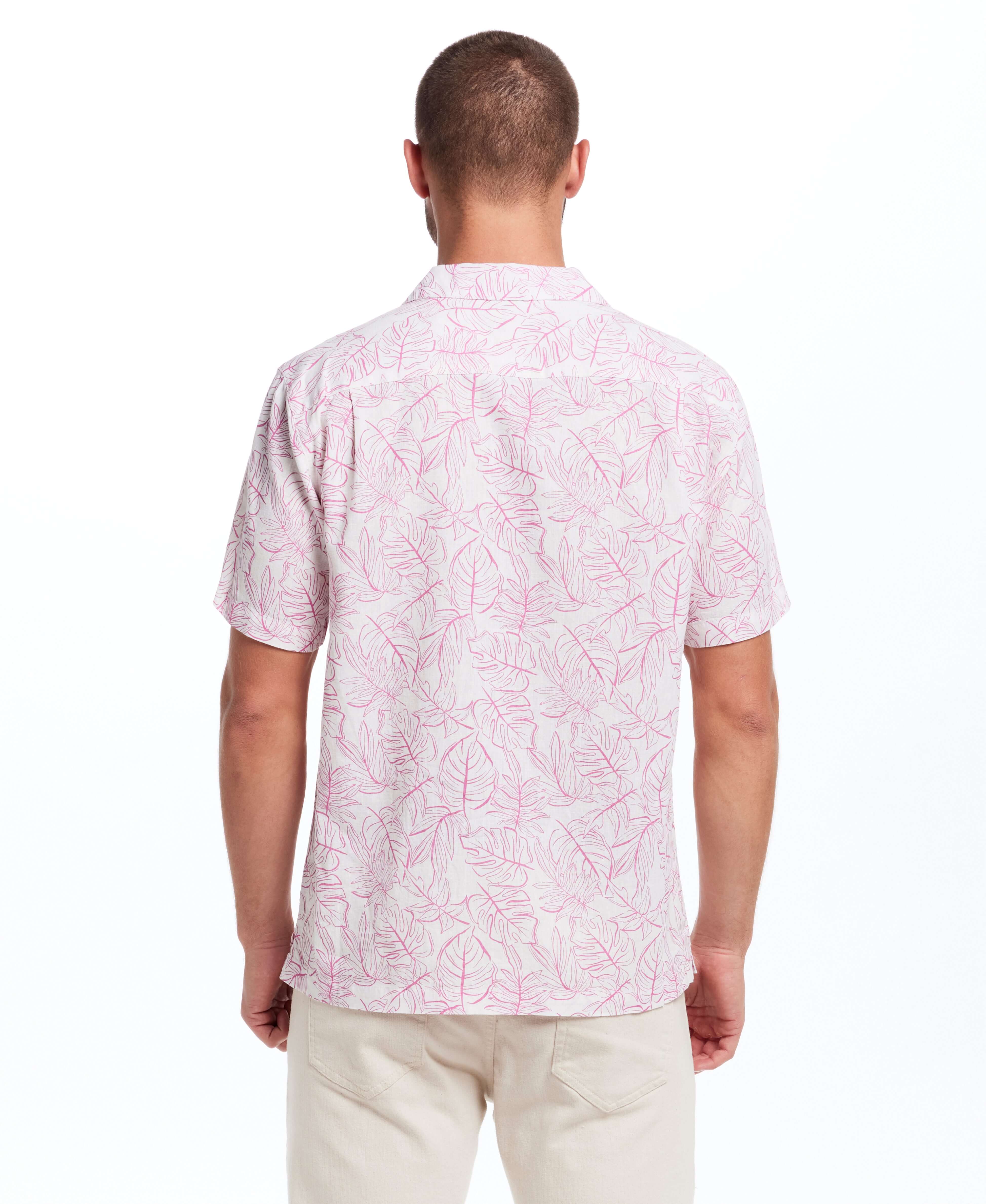 Back view of a man wearing a short sleeve linen cotton camp shirt in Wild Rose with a bold leaf print.