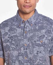 Short Sleeve Linen Cotton Floral Print In Bering Sea worn by a model, featuring a button down collar and cuffed short sleeves.