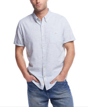 Man wearing a short sleeve solid linen shirt, showcasing a casual and stylish look with denim jeans.