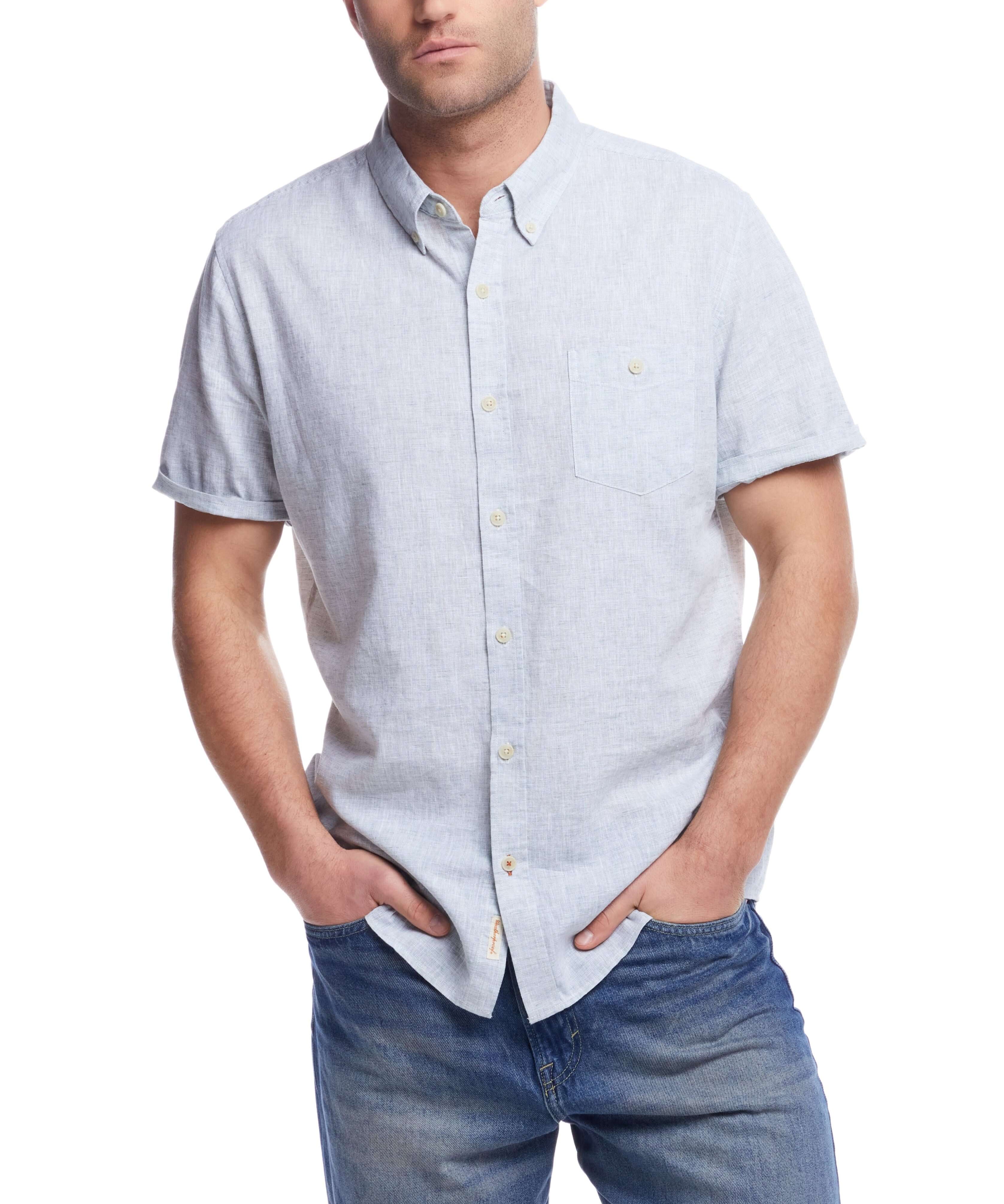 Man wearing a short sleeve solid linen shirt, showcasing a casual and stylish look with denim jeans.