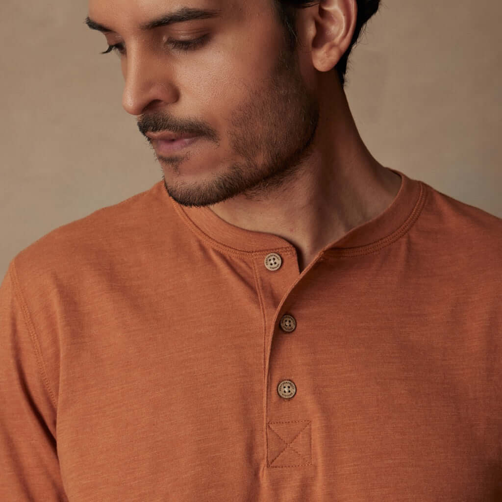 Classic short sleeve melange henley shirt in adobe color featuring a three-button placket and ribbed neck.