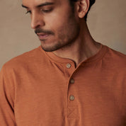 Classic short sleeve melange henley shirt in adobe color featuring a three-button placket and ribbed neck.