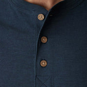 Close-up of deep cobalt henley shirt with button placket and ribbed details, showcasing quality craftsmanship.