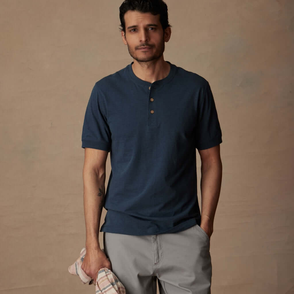 Man wearing a deep cobalt short sleeve melange henley shirt, showcasing comfort and classic style.
