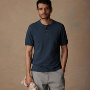 Man wearing a deep cobalt short sleeve melange henley shirt, showcasing comfort and classic style.