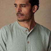 Model wearing a Short Sleeve Melange Henley in Sea Mist Heather, featuring a 3-button placket and rib-knit neck.