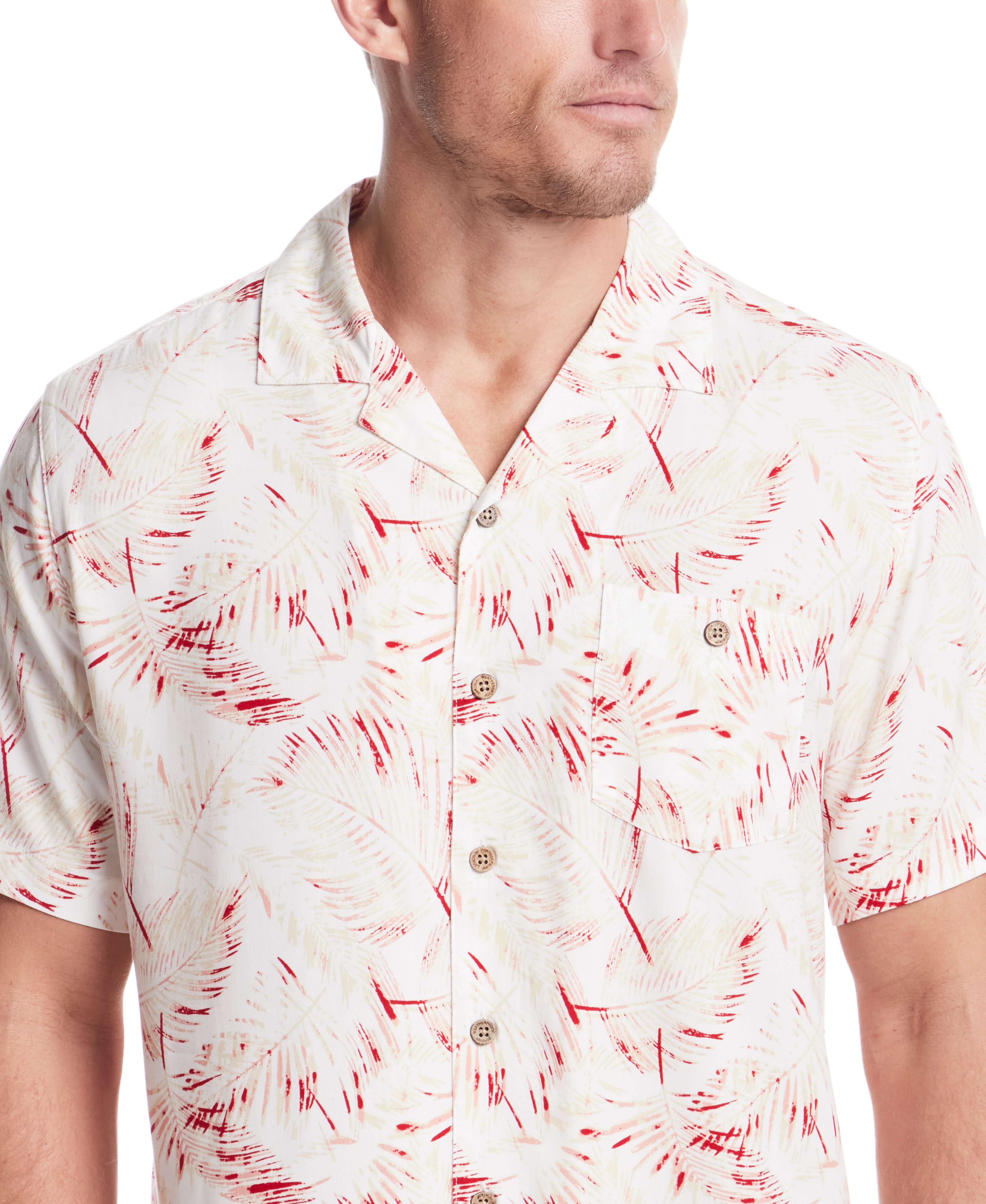 Model wearing a short sleeve rayon printed camp shirt in dusty pink with retro pattern and camp collar.