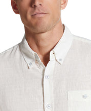 Close-up of a man wearing a bright white short sleeve linen cotton shirt with a button-down collar.