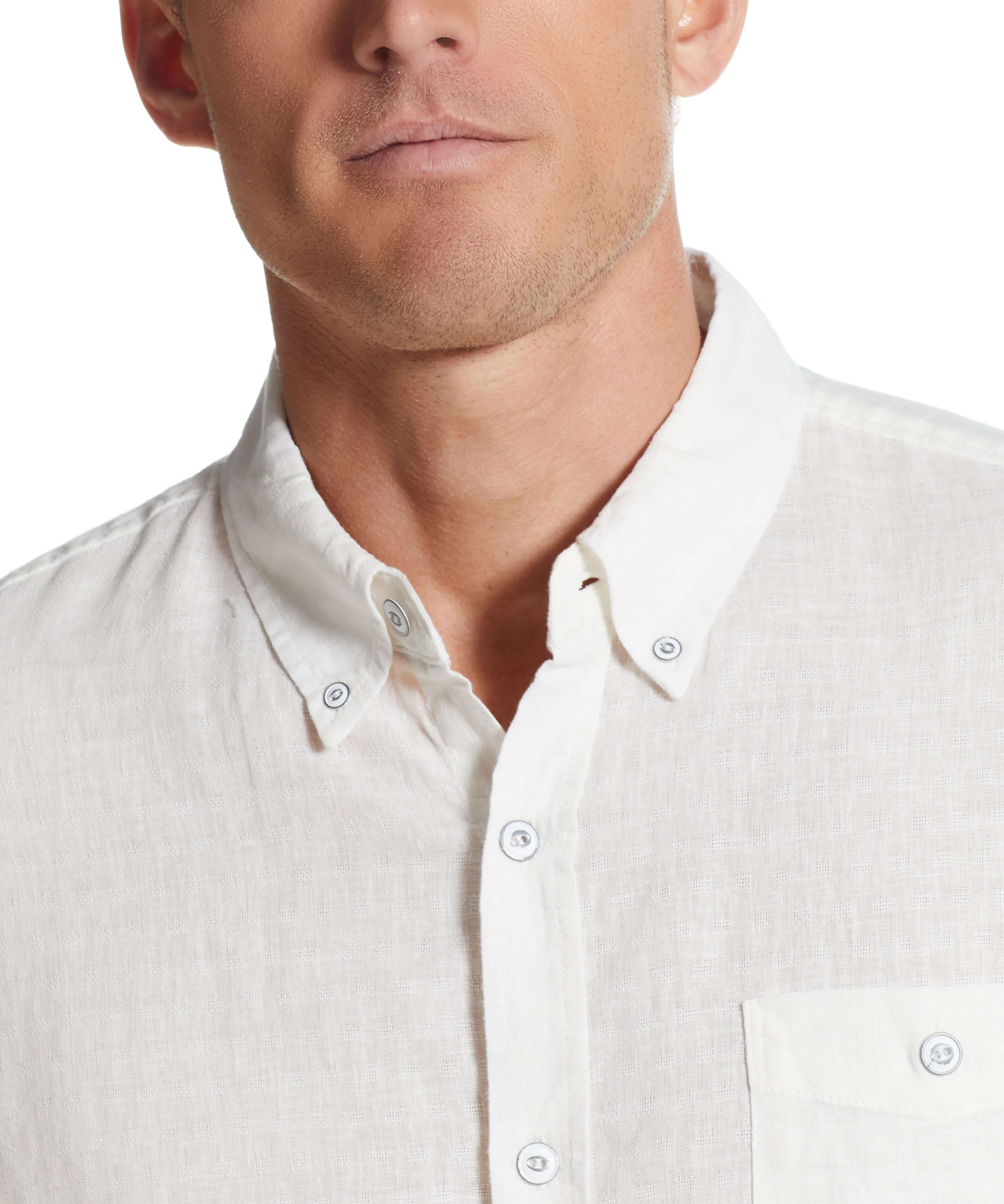 Close-up of a man wearing a bright white short sleeve linen cotton shirt with a button-down collar.