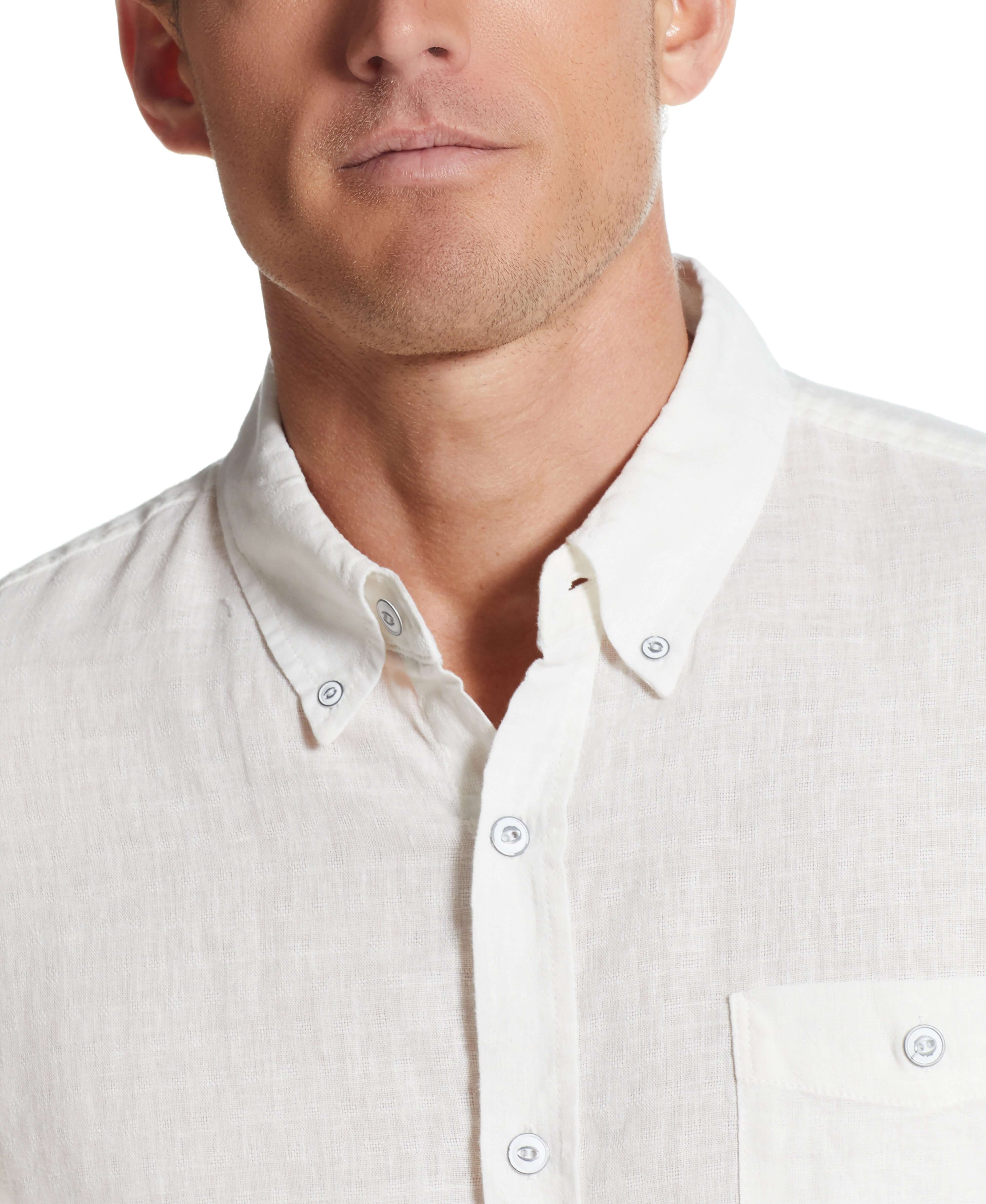 Close-up of a man wearing a bright white short sleeve linen cotton shirt with a button-down collar.
