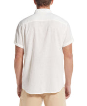 Back view of a man wearing a short sleeve solid linen cotton shirt in bright white.