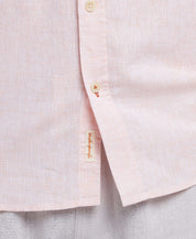 Close-up of a light pink linen shirt with buttons, featuring a casual and stylish blend of comfort and elegance.