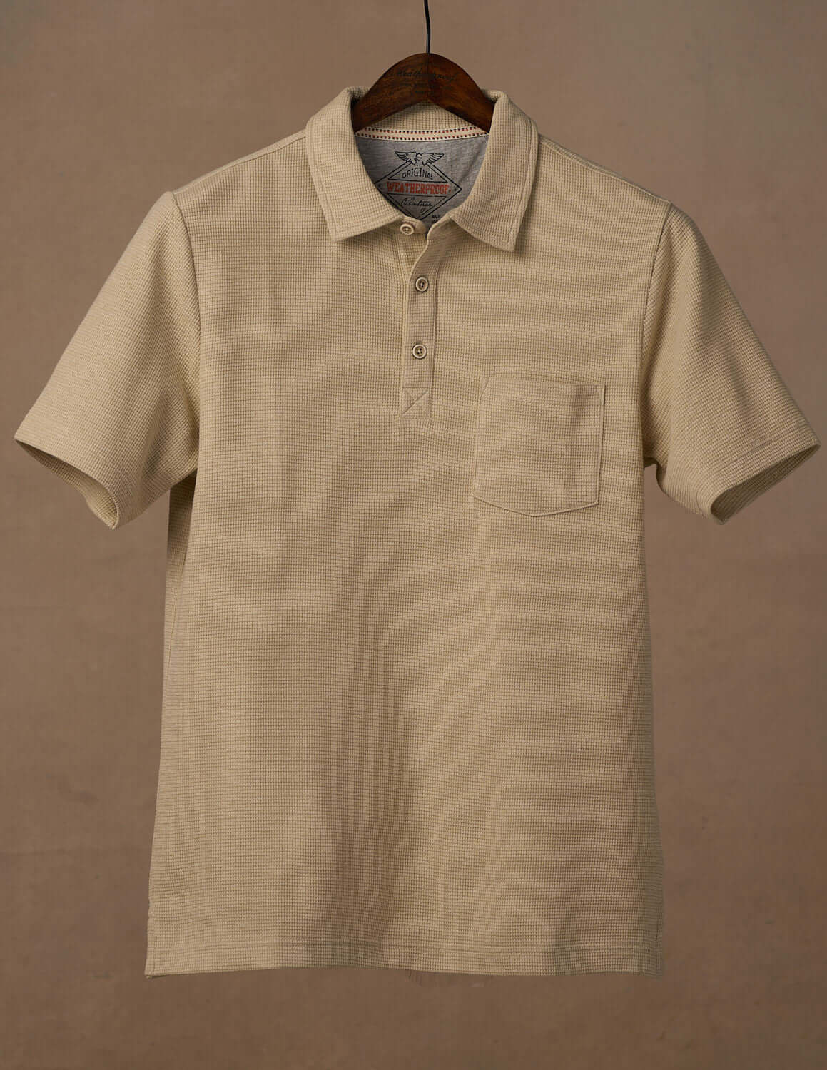 Short Sleeve Waffle Polo in Bleached Sand with 3 button placket and chest pocket, featuring a soft waffled texture.