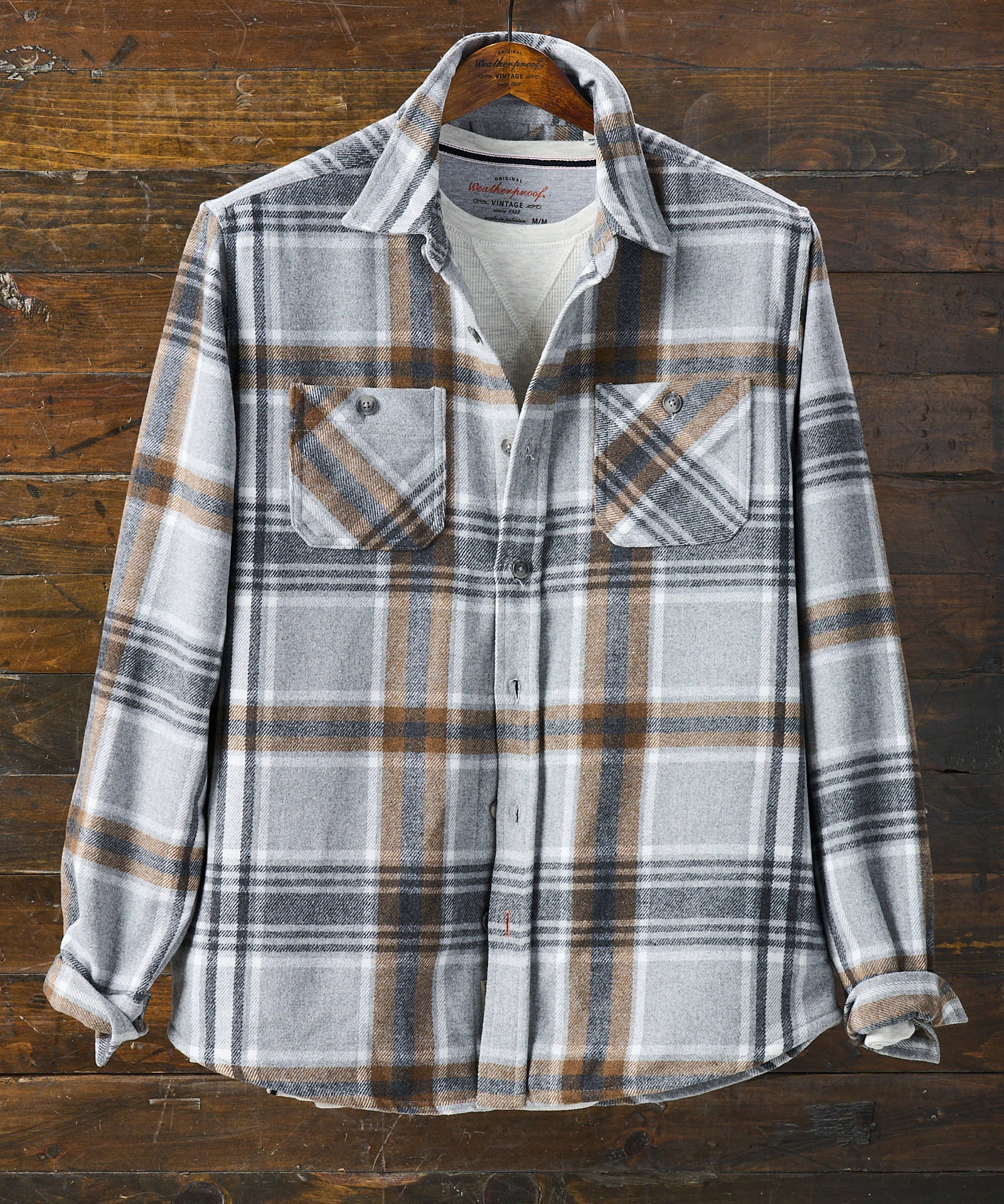 Wool Blend Plaid Shirt Jacket in Castor Grey hanging on wooden background, featuring buttoned pockets.