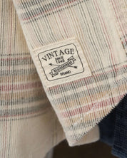 Close-up of the label on the Long Sleeve Plaid Cord Shirt in Natural, showcasing vintage branding details.
