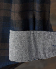 Close-up of the cuff of a long sleeve brushed flannel shirt in toffee and blue, featuring a button-down design.