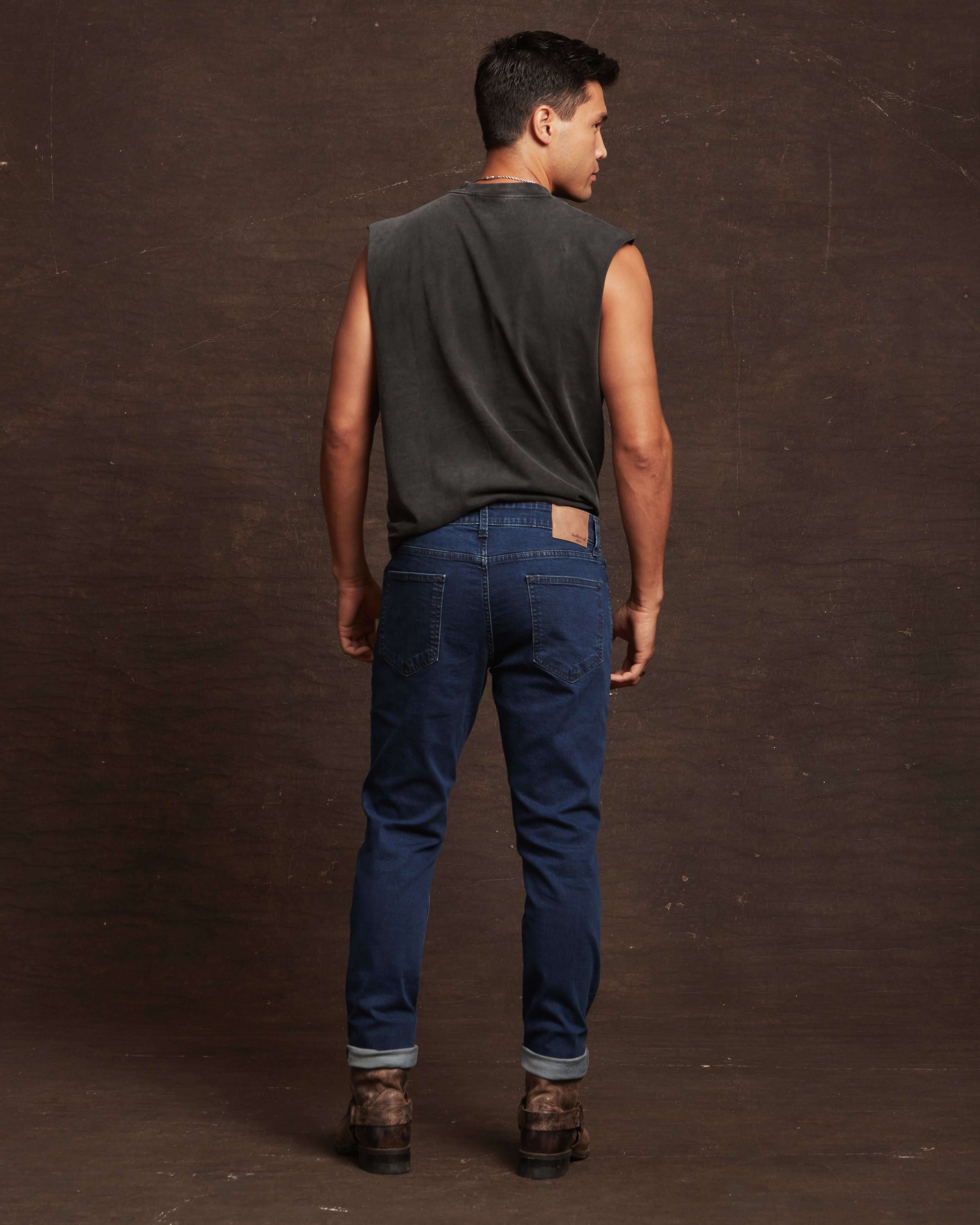 Man wearing slim fit denim jeans in Carolina blue, showcasing the back view with a comfortable and stylish look.