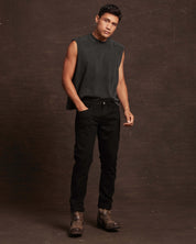 Slim fit denim jeans in jet black worn by a model, showcasing a stylish, contemporary look with a sleeveless top.