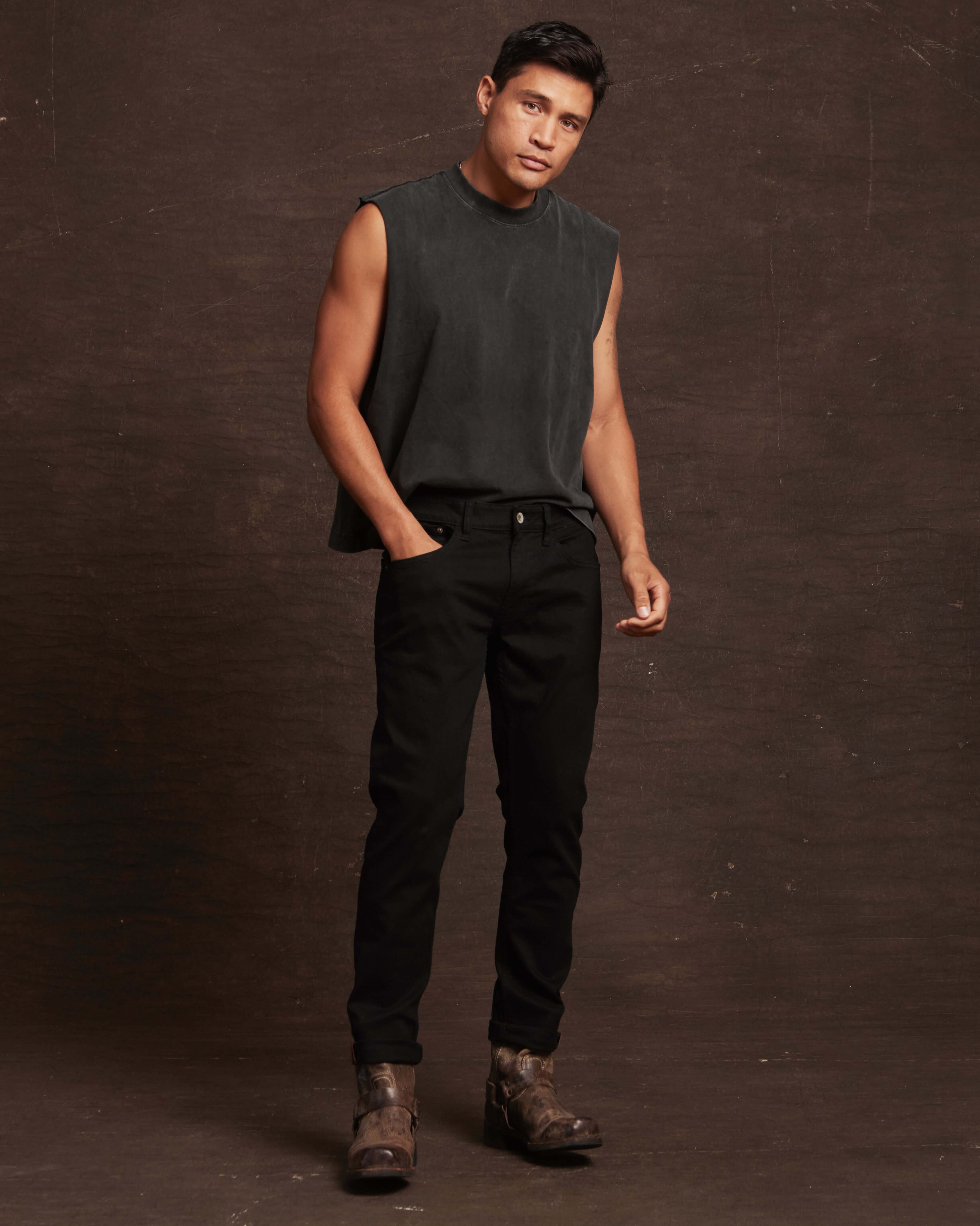 Slim fit denim jeans in jet black worn by a model, showcasing a stylish, contemporary look with a sleeveless top.