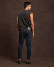 Rear view of a model wearing slim fit denim jeans in Moon Shadow, showcasing comfort and style with a tailored look.