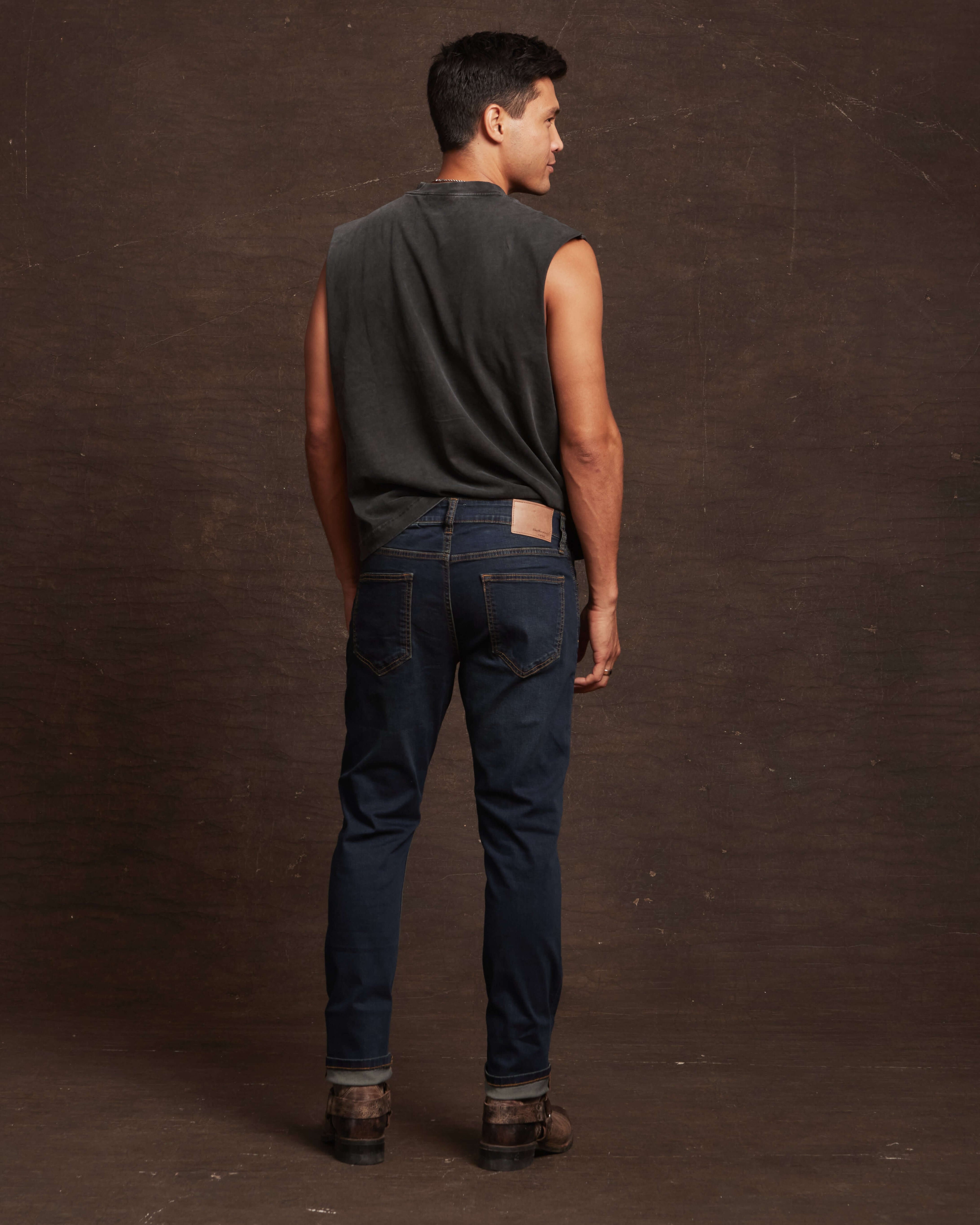 Rear view of a model wearing slim fit denim jeans in Moon Shadow, showcasing comfort and style with a tailored look.