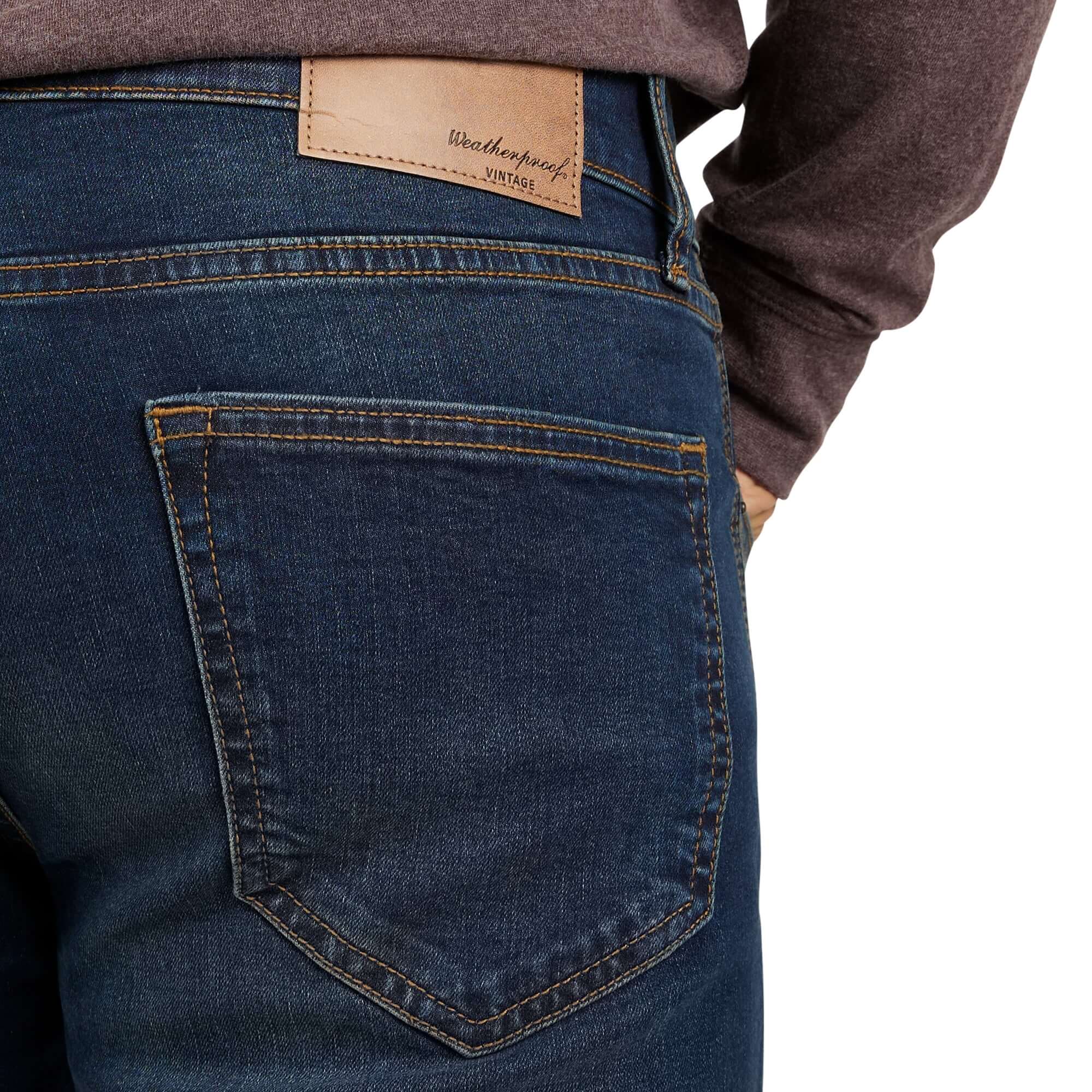 Close-up of slim fit denim jeans in Moon Shadow, showcasing the back pocket and leather logo patch.