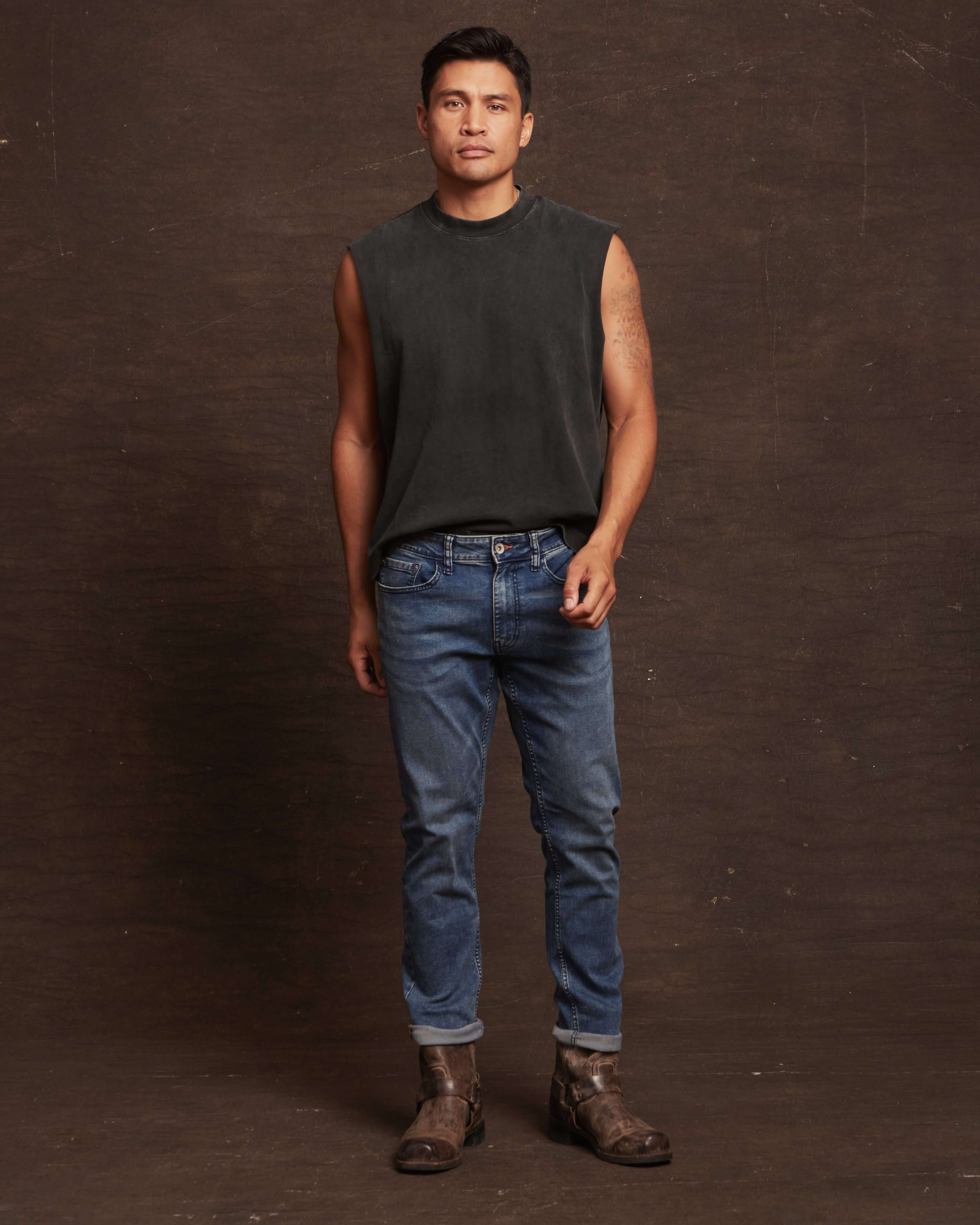Slim fit denim jeans in Niagara on a model, paired with a sleeveless top and stylish boots, showcasing comfort and style.