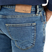 Close-up of slim fit denim jeans in rocker blue, showcasing back pocket and leather label, perfect for a stylish look.