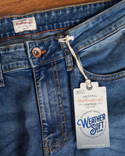 Close-up of slim fit Rocker Blue denim jeans featuring Weather Soft denim tag and button detail.
