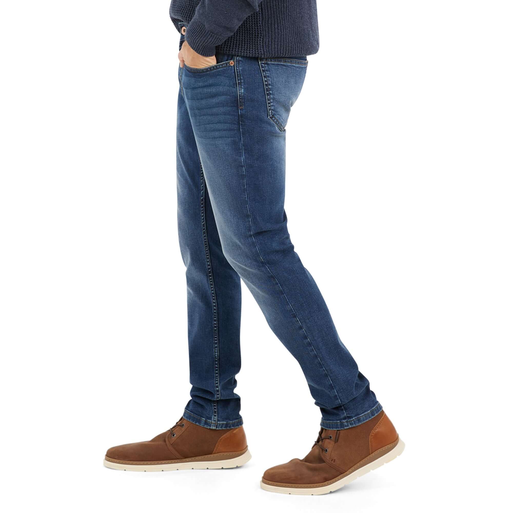 Slim fit stretch denim jeans in soft blue, featuring a comfortable design and casual look, paired with brown boots.