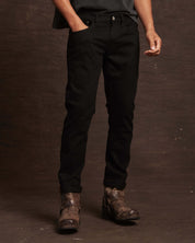 Slim fit denim jeans in jet black with all-way stretch, styled with a casual look and paired with rugged boots.