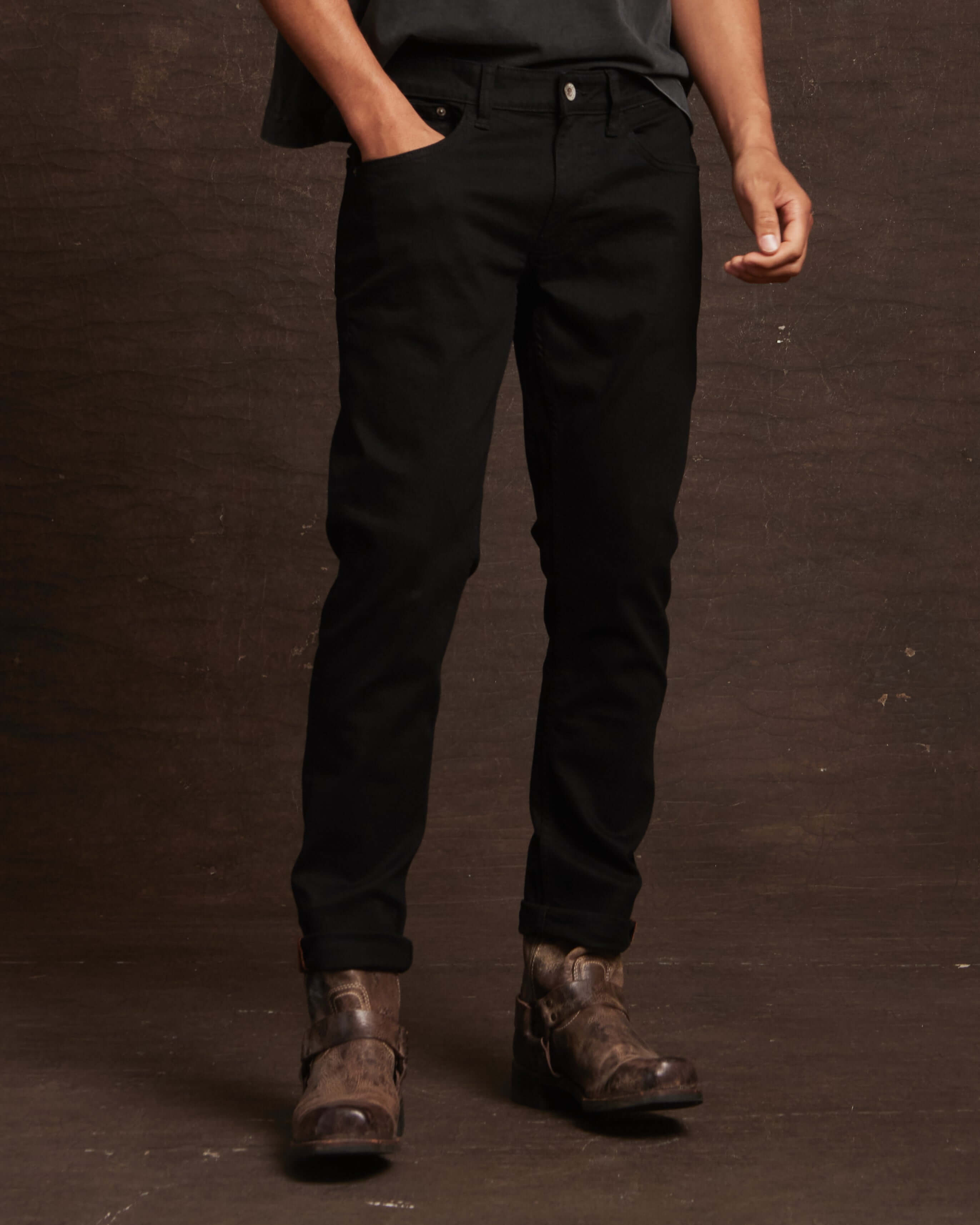 Slim fit denim jeans in jet black with all-way stretch, styled with a casual look and paired with rugged boots.