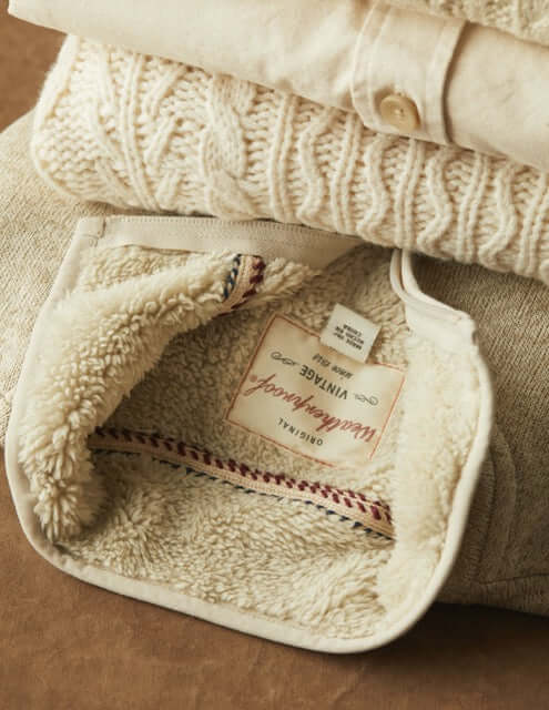 Close-up of sherpa lining inside a sweaterfleece pullover, showcasing soft texture and cozy warmth.