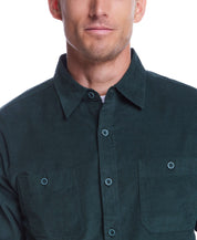 Model wearing a thin wale solid cord shirt in scarab color, featuring a button-down collar and two chest pockets.
