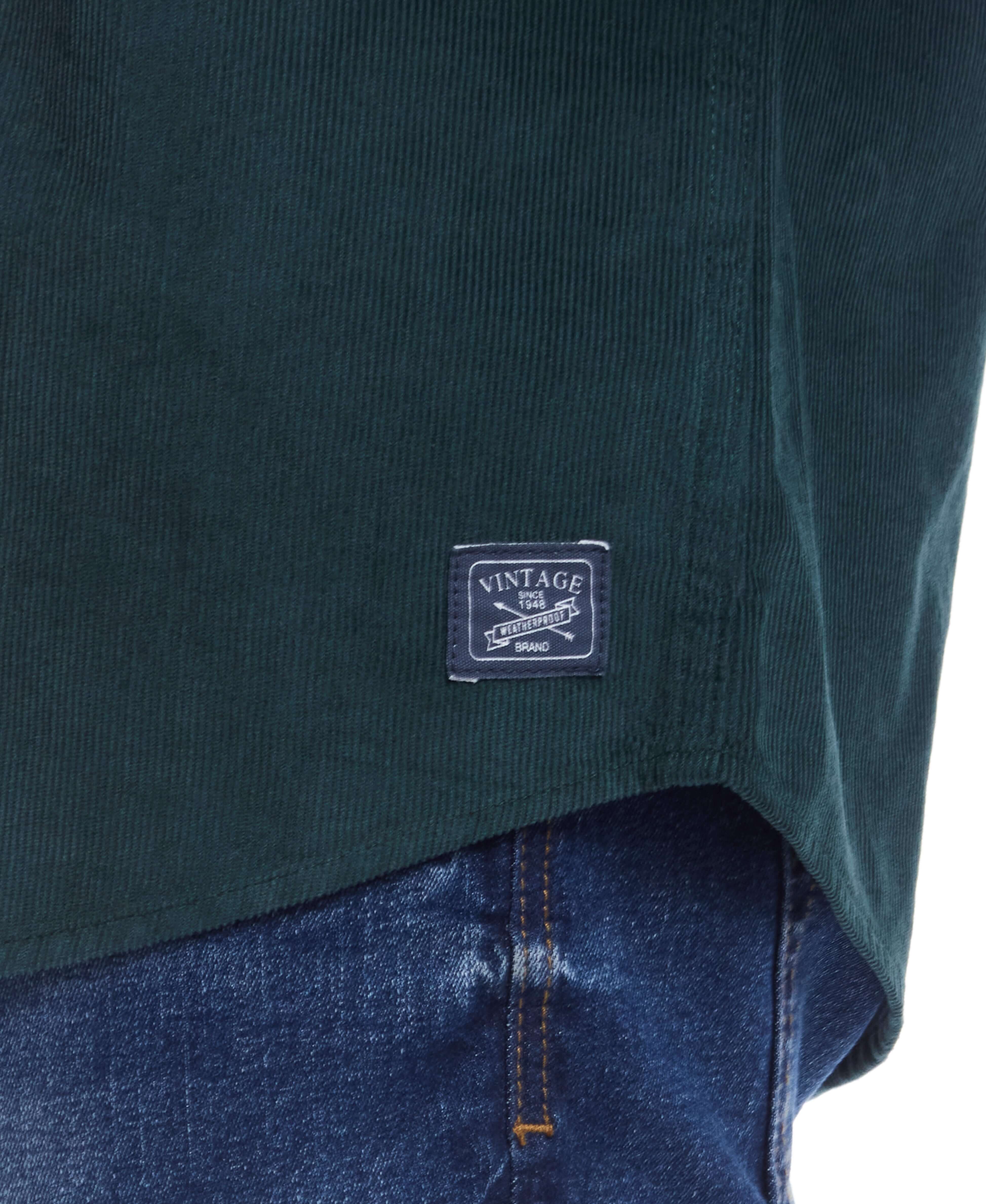 Close-up of the Thin Wale Solid Cord Shirt in Scarab showcasing the vintage label and soft corduroy texture.