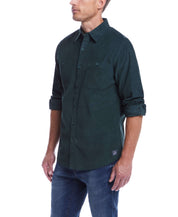Model wearing a thin wale solid cord shirt in Scarab, featuring a button down collar and buttoned chest pockets.