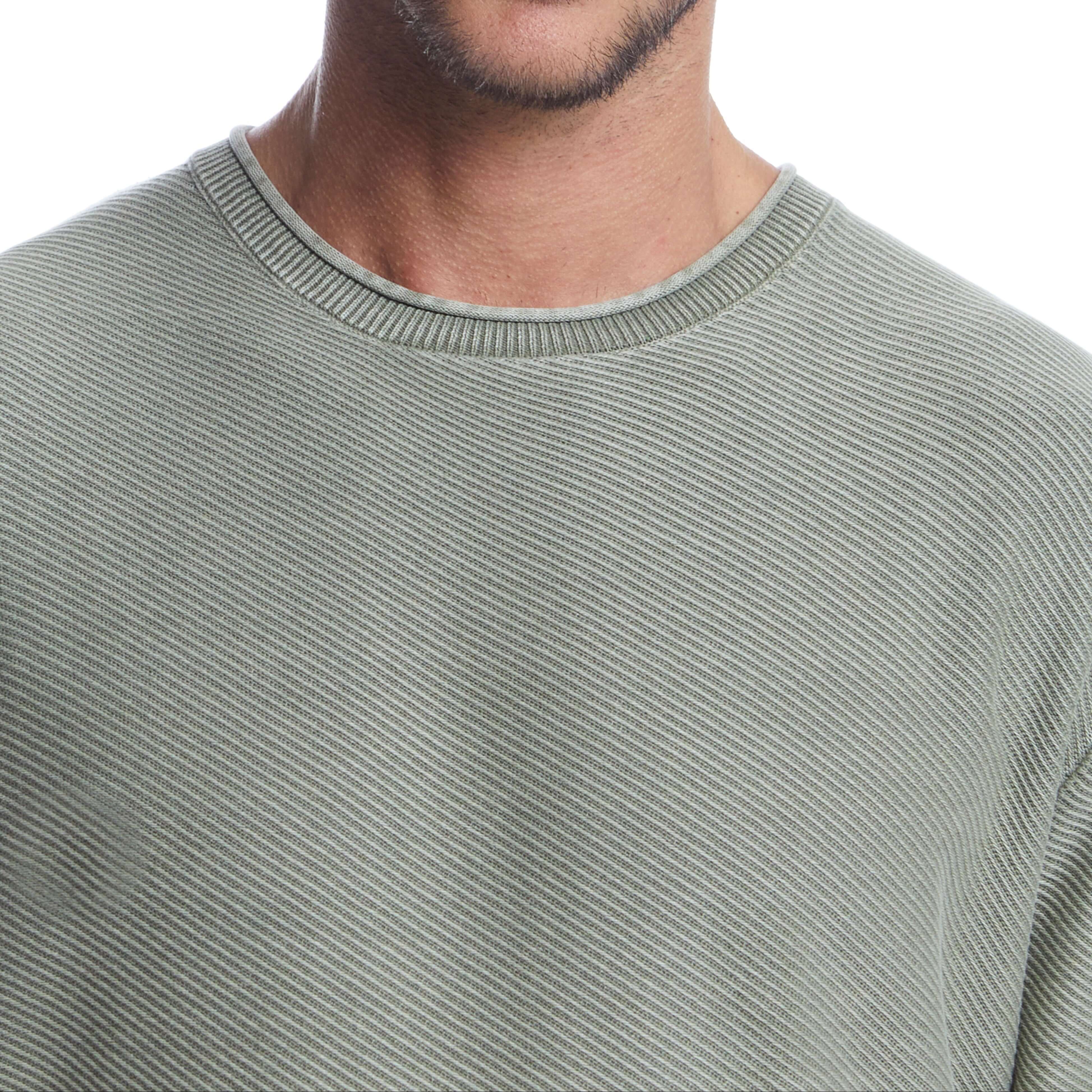 Close-up of a soft cotton twill stonewash sweater in moss, featuring a classic roll-neck design and textured rib knit.