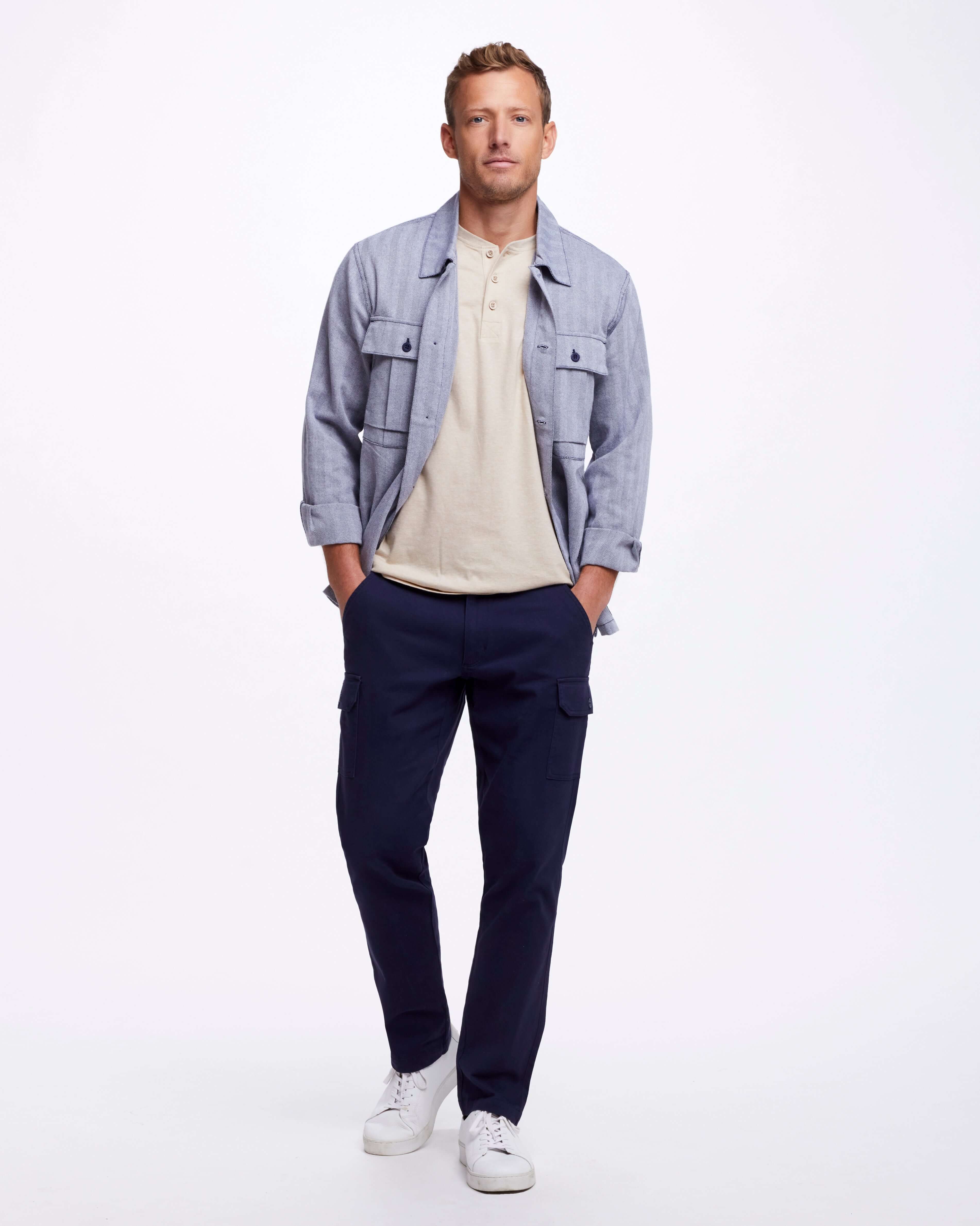 Man wearing Cargo Pant In Navy with a light jacket and polo, showcasing a stylish, casual look ideal for any season.