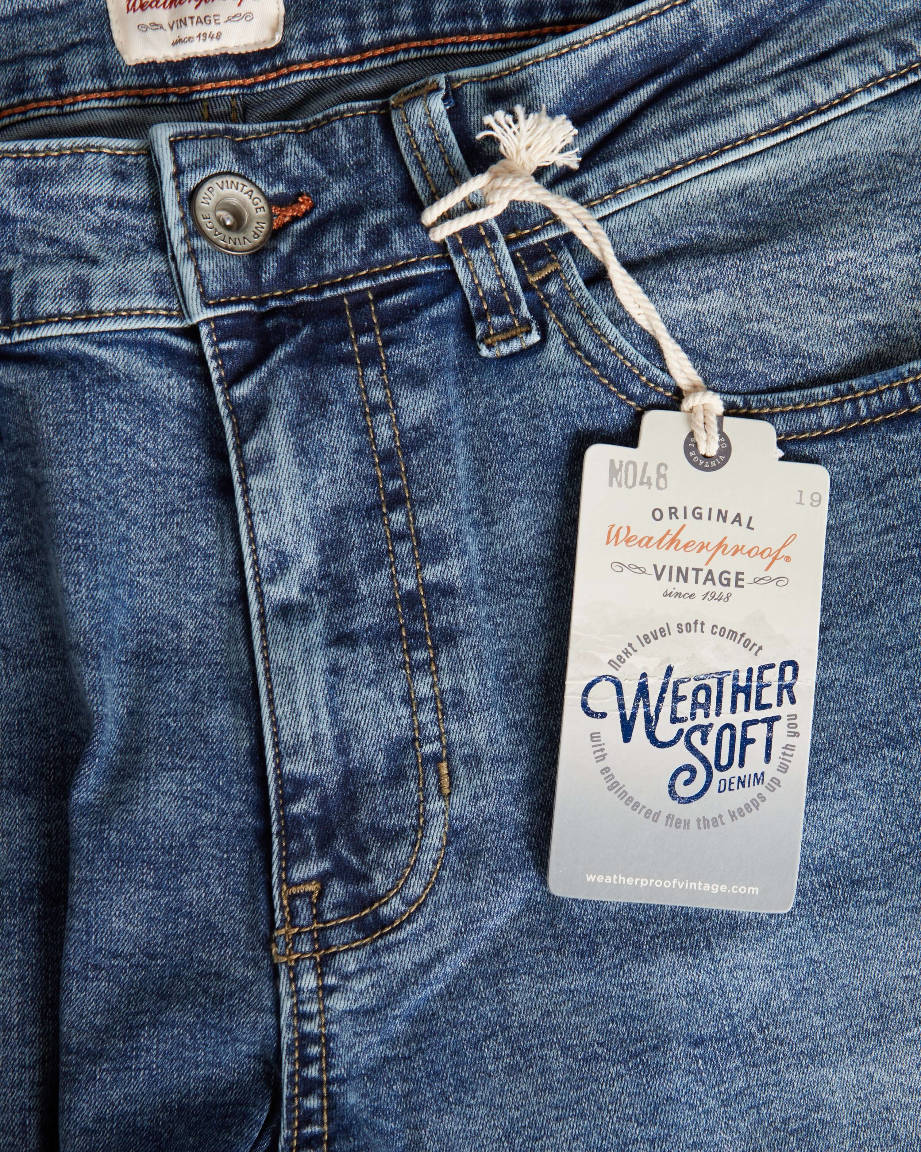 Close-up of weatherproof vintage denim jeans showcasing soft fabric and price tag details.