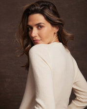 Model showcasing a women's ecru cashmere long sleeve sweater in a soft, classic fit.