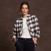 Model wearing a black and white plaid women's stretch flannel with notch V-neck and rolled sleeves.