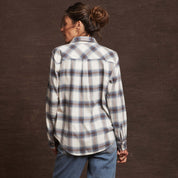 Back view of a woman in a blue and white checked women's flannel shirt with a classic fit and rolled sleeves.