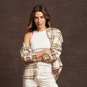 Model wearing a women's stretch flannel shirt in green, styled with a white tank top and light jeans, showcasing comfort and fashion.