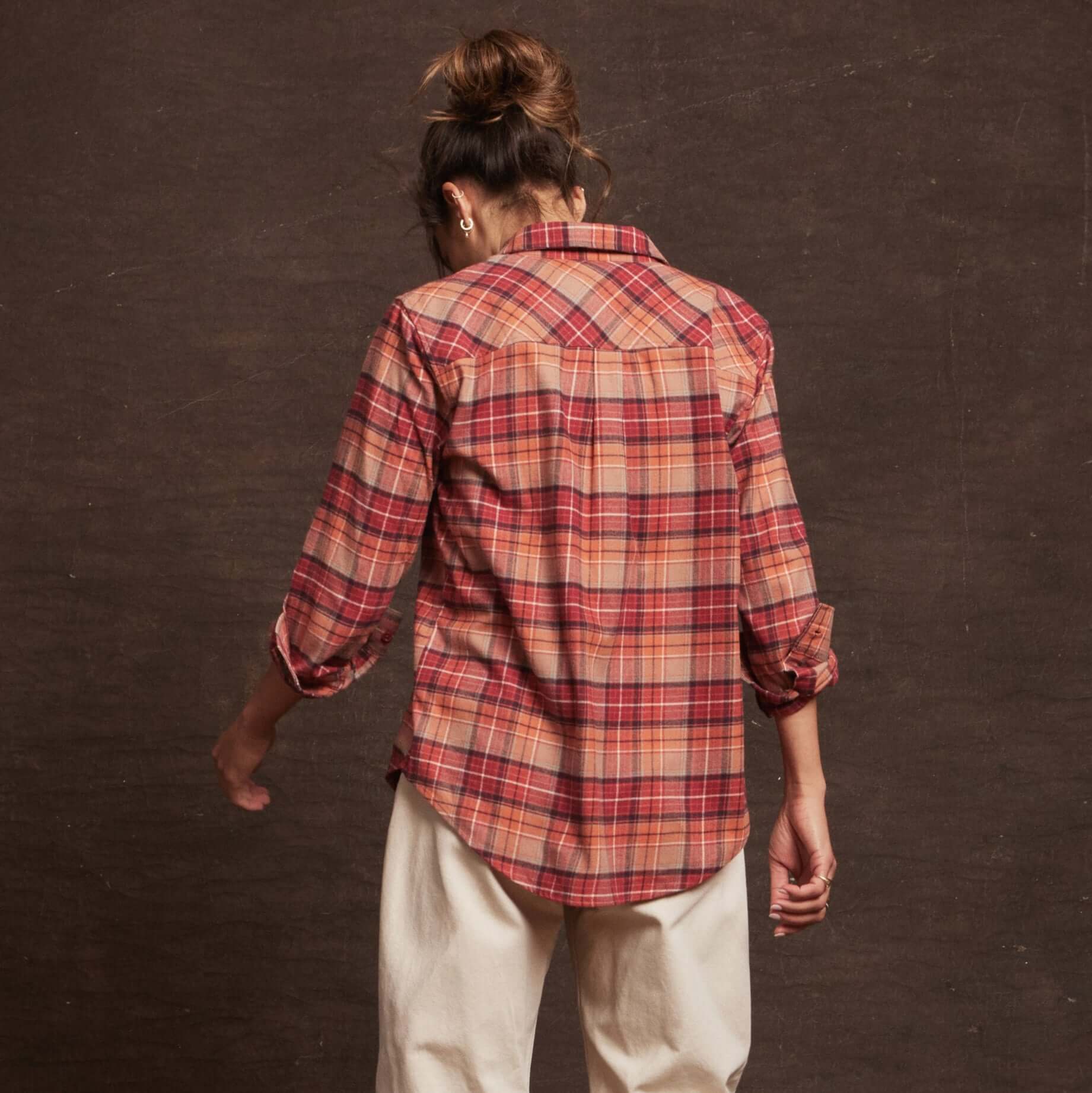 Back view of a Women's Stretch Flannel in orange plaid, featuring a classic fit and rolled sleeves for a casual style.