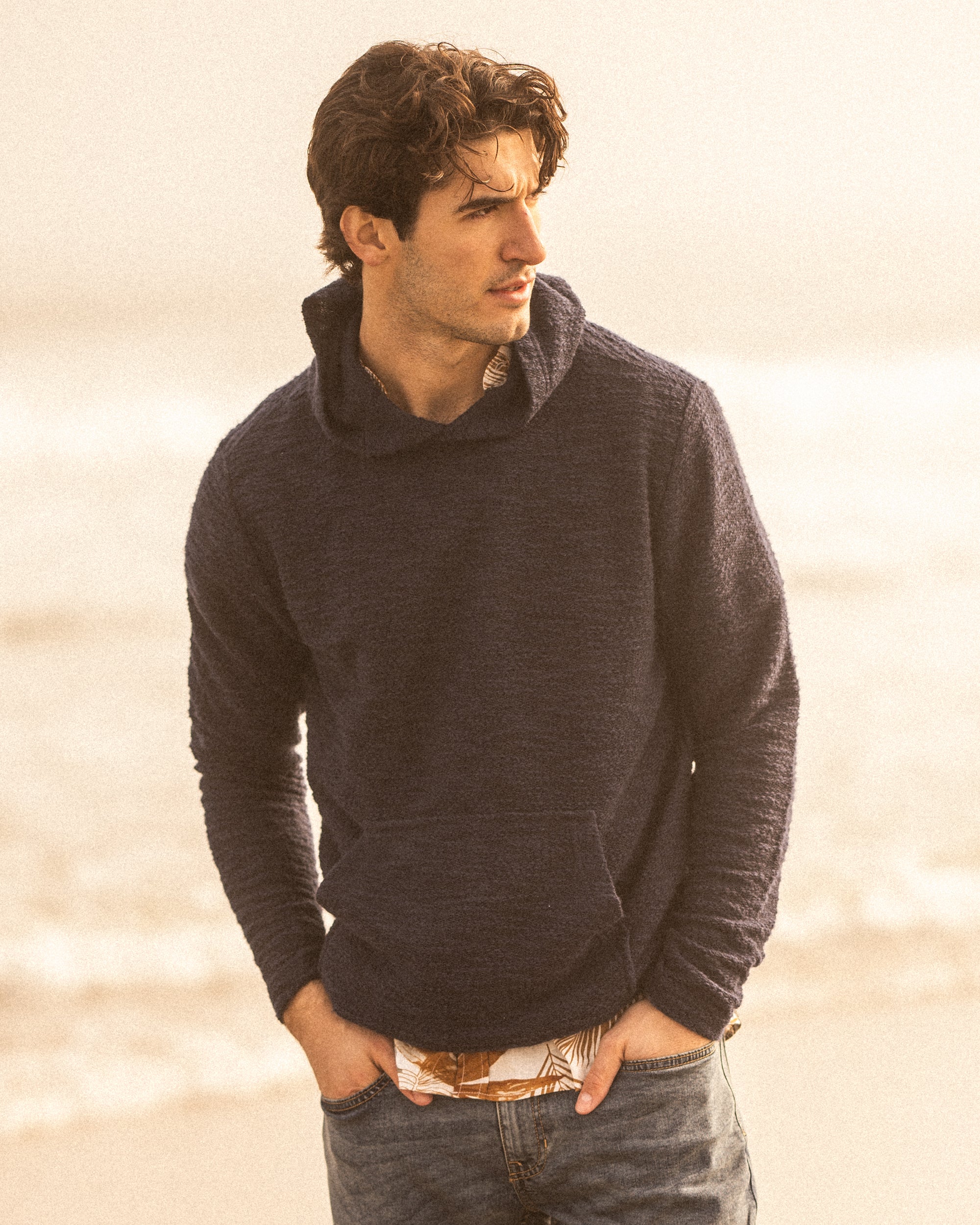 Model wearing Slub Knit Pullover Hoodie in Maritime Blue at the beach, showcasing its stylish design and comfort.