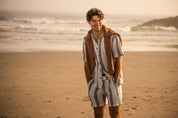 Linen Rayon Stripe Camp Shirt in Blue & White Stripe worn by man at the beach, complemented with matching shorts.