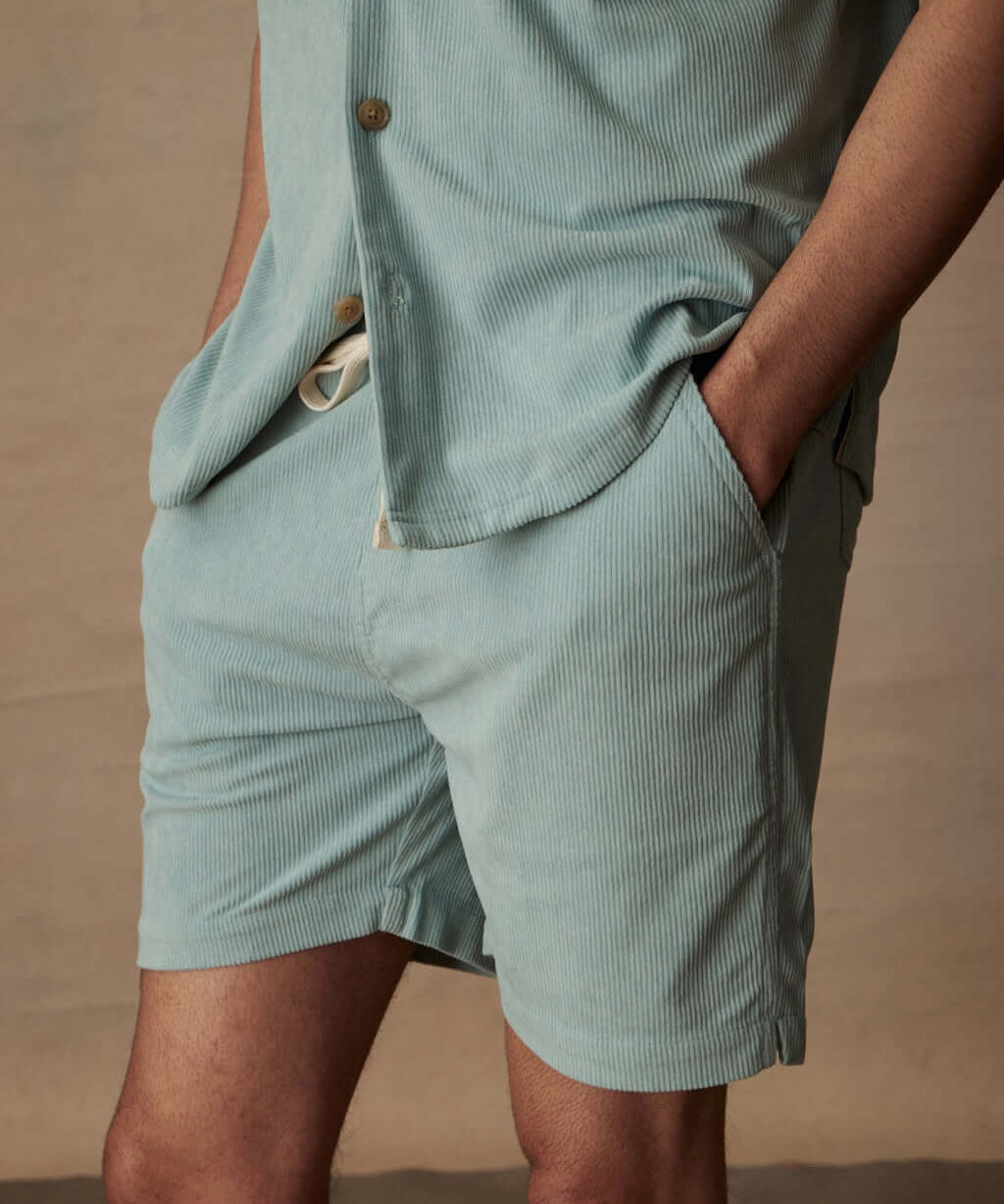 Model showcases 6" corduroy cabana shorts in teal mist, featuring a stretch waistband and side pockets.