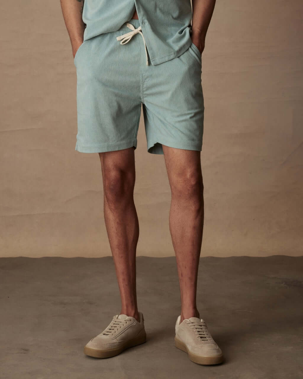 Model in teal mist 6" corduroy cabana shorts, paired with neutral sneakers, showcasing a classic fit and adjustable drawstring.